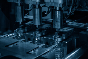 The drinking water bottle manufacturing process by blow mold machine in the light blue scene.