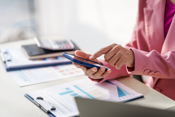 40-year-old middle-aged Asian businesswoman wearing pink suit, business finance, investment strategies, risk management. Skilled in planning, analysis, operations control for business success.