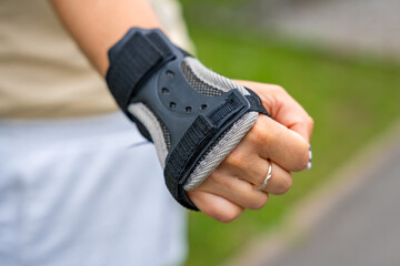 Close up view of hand in protection glove of roller skater woman in inline skates rollerblading in...