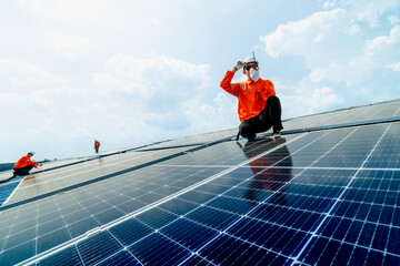 engineer man inspects construction of solar cell panel or photovoltaic cell by electronic device. Industrial Renewable energy of green power. factory worker working on tower roof.