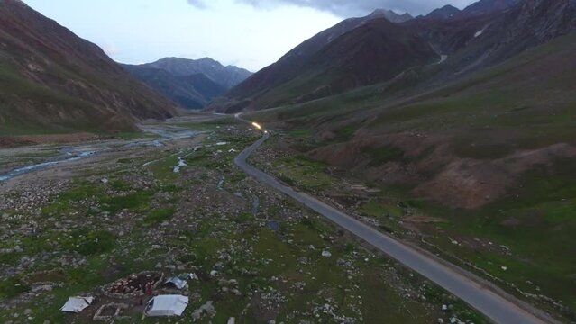 Aerial view of Naltar Valley with majestic mountains, remote road, and tranquil river, Gilgit-Baltistan, Pakistan.