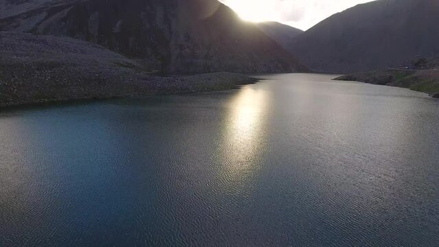 Aerial view of serene lake and majestic mountains at dusk, Kaghan Valley, Naran, Mansehra District, Khyber Pakhtunkhwa, Pakistan.