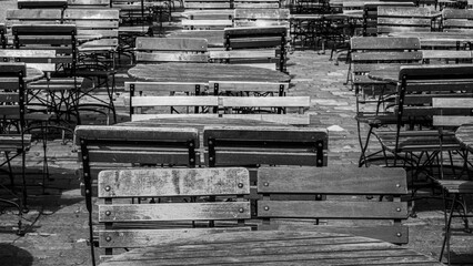 A Series of Empty Wooden Tables and Chairs Outside a Cafe in Bergen Norway