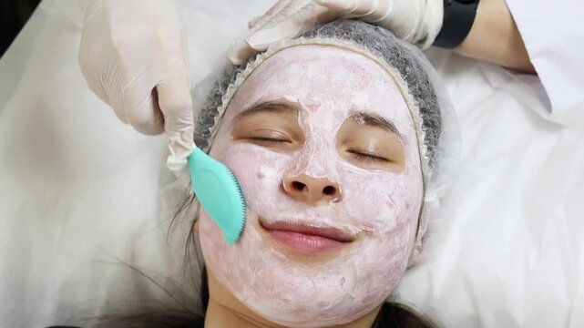 Woman using spatula to apply moisture anti-wrinkle mask before facial foundation, moisturizer cream, looking in mirror. Face skincare, professional mask product cosmetics. Non-surgical rejuvenation
