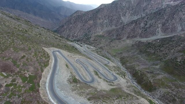 Aerial view of winding road through majestic mountains and serene valley, Babusar Pass, Kaghan Valley, Pakistan.