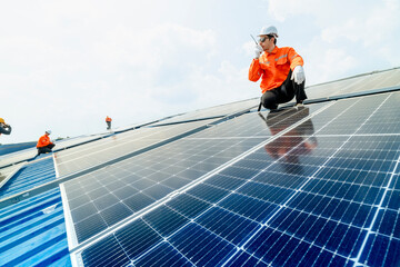 engineer man inspects construction of solar cell panel or photovoltaic cell by electronic device. Industrial Renewable energy of green power. factory worker working on tower roof.