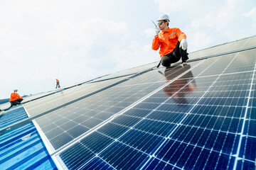 engineer man inspects construction of solar cell panel or photovoltaic cell by electronic device. Industrial Renewable energy of green power. factory worker working on tower roof.