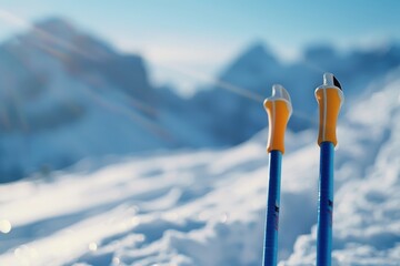 Closeup of ski poles planted in snowy mountains with a blurred background