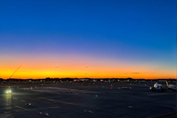 Sky high traffic, sunset arrival with blurred tail of parked plane and approaching jet - stock photo