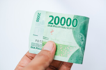hand holding twenty thousand rupiah isolated on white background