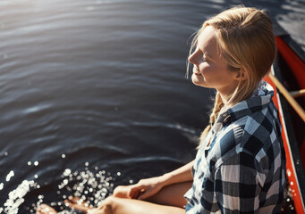 Fototapeta premium Woman, lake and holiday with feet in water, relax on vacation with calm in nature for wellness. Female person, happiness and river travel with sunshine, kayak for adventure tourism in Canada