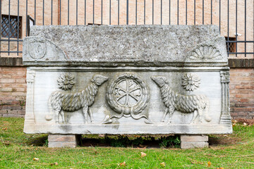 Two carved lambs decorating ancient marble sarcophagus in exhibition in Ravenna