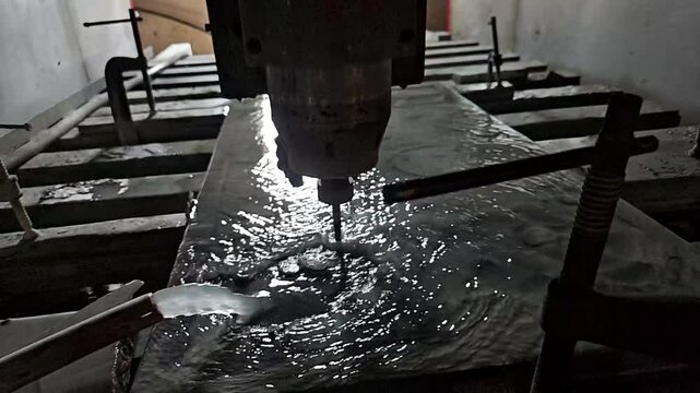 Diamond cutting scene with Computer Numerical Control (CNC) machine. Water jets fly in different directions, slow motion.