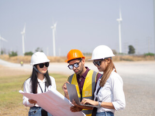 A group of engineers and architects are consulting. About taking care of wind turbines For a sustainable environment