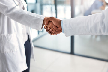 People, medical and doctor hand shake in hospital, medicine and wellness with healthcare professional. Trust, support and agreement for partnership or collaboration, thank you and welcome gesture