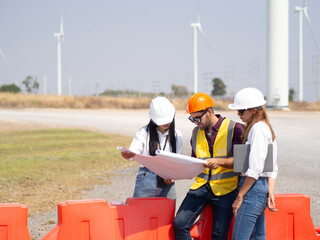 A group of engineers and architects are consulting. About taking care of wind turbines For a sustainable environment