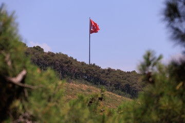 Turkish flag, on a red background white star and moon. Turkish flag flies in the wind against the...