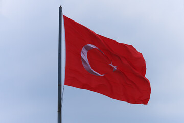 Turkish flag, on a red background white star and moon. Turkish flag flies in the wind against the backdrop of Istanbul