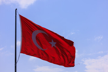 Turkish flag, on a red background white star and moon. Turkish flag flies in the wind against the backdrop of Istanbul