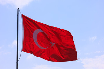 Turkish flag, on a red background white star and moon. Turkish flag flies in the wind against the backdrop of Istanbul