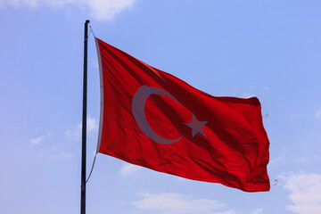 Turkish flag, on a red background white star and moon. Turkish flag flies in the wind against the backdrop of Istanbul