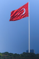 Turkish flag, on a red background white star and moon. Turkish flag flies in the wind against the backdrop of Istanbul