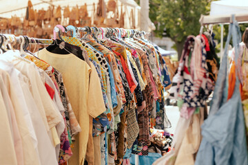 Choice of fashion clothes of different colors on hangers in a retail shop. Flea market with old...