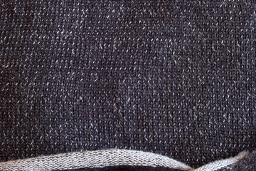 Close up of a sweater with  white and dark gray threads creates a monochromatic depth. The bottom...