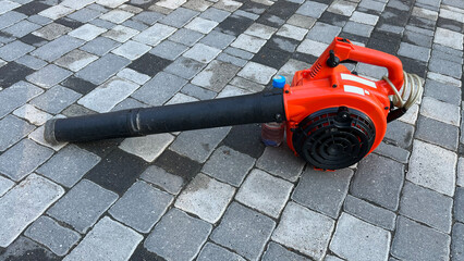 A gasoline blower in close-up on a paving stone. A gasoline tool for cleaning foliage in autumn....