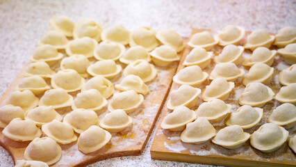 Homemade dumplings close-up. handmade dumplings on a wooden board, selective focus, tinted image, traditional Russian dish,