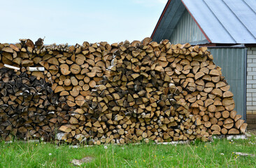 a pile of wood next to a building with a steel roof