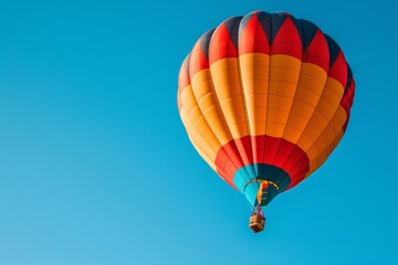 Obraz premium Colorful hot air balloon soaring in clear blue sky for adventurous escape and scenic journey