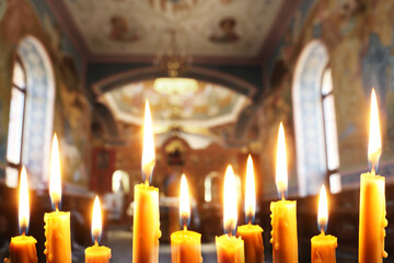 Many church candles burning in temple, closeup