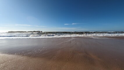 Plage sereine avec vagues douces sous un ciel bleu