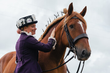 Traditional English horse riding and clothing, beautiful equestrian style dress and hat, woman with...