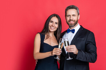 Couple in love celebrate engagement. Elegant couple drink champagne isolated on red. Couple at formal occasion. Romantic date celebrations. Valentines day advertisement. Celebrate anniversary
