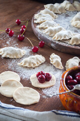 Cooking homemade varenyky (dumplings) with cherry. Ukrainian national quisine