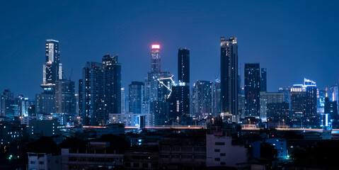 City night landscape tall tower buildings on dark blue sky background
