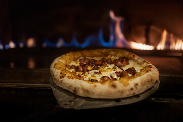 Mexican pizza with jalapeño, tortilla chips, sausage and chili flakes