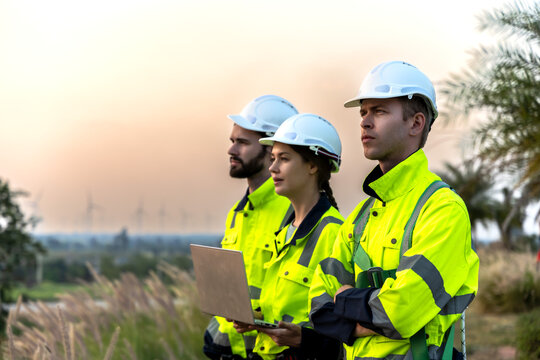 Wind turbine men and woman engineers working as team in windmill field