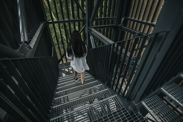 A close-up view of a metal staircase inside an industrial structure, with light filtering through...