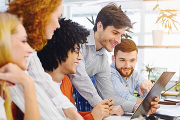 Obraz premium New business plan. Young cheerful people looking at clipboard at coworking workplace, free space