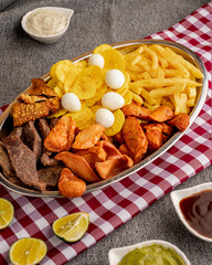 Colombian picada with chopped beef, chicharron (fried pork skin), quail eggs, chorizo, plantain chips, and french fries