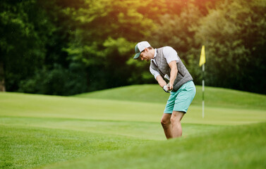 Man, happy and playing golf at field as sports talent or professional skill and training. Hobby,...