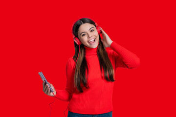 Generation z lifestyle. Millennial girl choose song in playlist. Teen girl isolated on red....