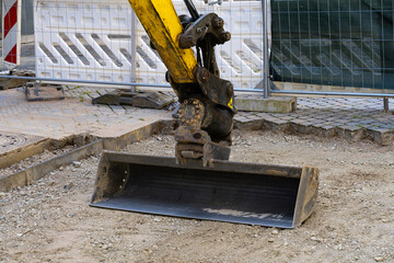 Narrow and elongated excavator bucket on a construction site.