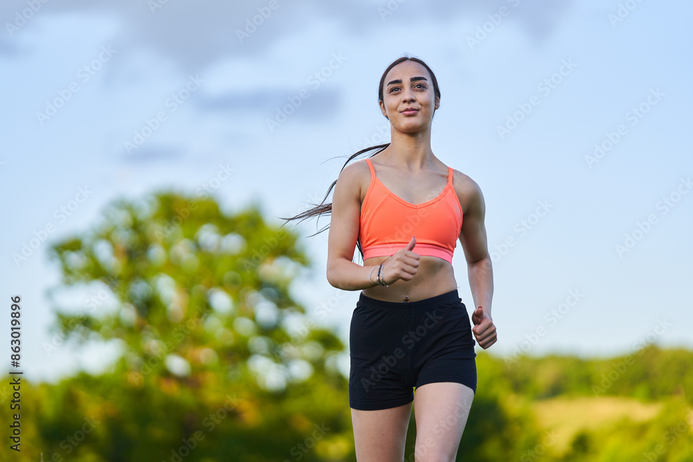 Wall mural latin girl running on a trail in the forest