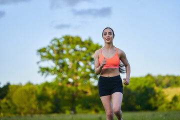 Latin girl running on a trail in the forest
