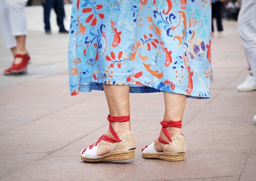 Close-up of a woman wearing traditional white espadrilles with red laces, worn by sardana dancers at catalan traditional festivals. Sardanista with espardenyes