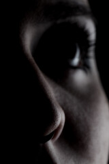 Obraz premium Side lit silhouette portrait of a girl against black background. Abstract eye looking up.